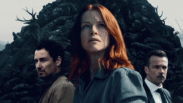 Three people standing in front of a dark, forest-like background, representing the sound design work for the series Oderbruch.